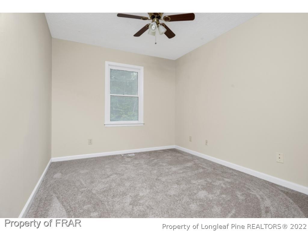 6549 Rhemish Drive Fayetteville, NC 28304 - Photo 23 of 27 an empty room with windows and ceiling fan