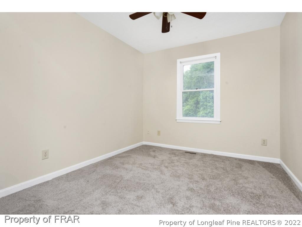 6549 Rhemish Drive Fayetteville, NC 28304 - Photo 25 of 27 an empty room with a window and a ceiling fan