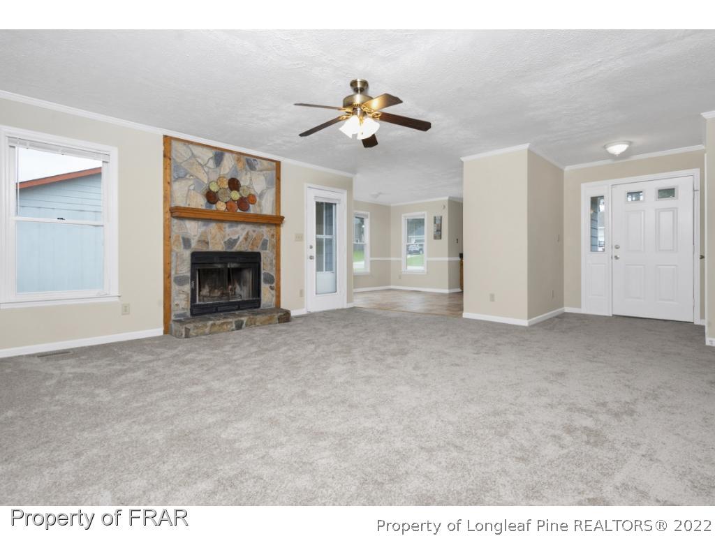 6549 Rhemish Drive Fayetteville, NC 28304 - Photo 8 of 27 a view of a livingroom with a ceiling fan fireplace and a window