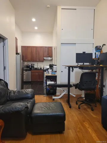a living room with stainless steel appliances furniture a rug and a view of kitchen