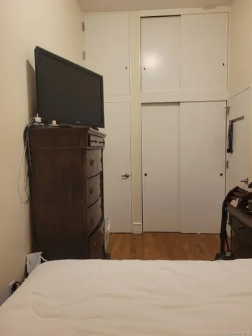 a bedroom with a bed and a television