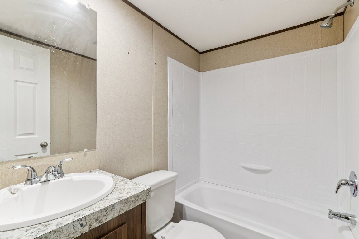 24369-2 Bingham Creek Road, Unit 8 Leander, TX 78641 - Photo 11 of 16 a bathroom with a granite countertop sink and a mirror