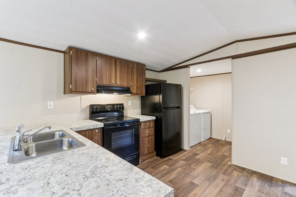 24369-2 Bingham Creek Road, Unit 8 Leander, TX 78641 - Photo 7 of 16 a kitchen with stainless steel appliances granite countertop a refrigerator sink and stove