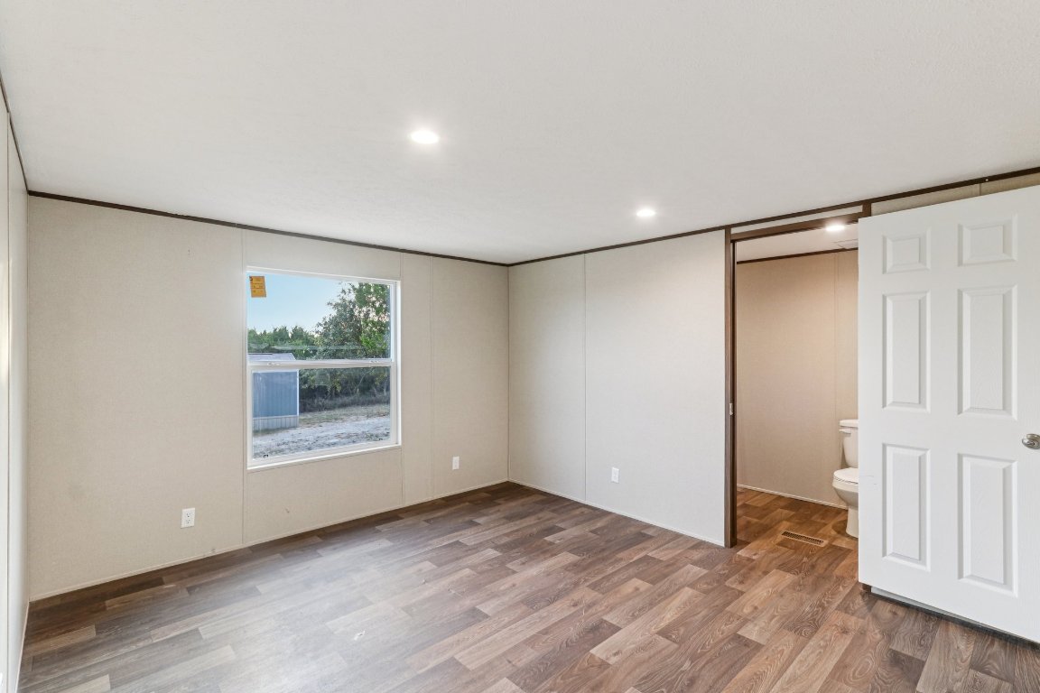 24369-2 Bingham Creek Road, Unit 8 Leander, TX 78641 - Photo 8 of 16 wooden floor in an empty room with a window