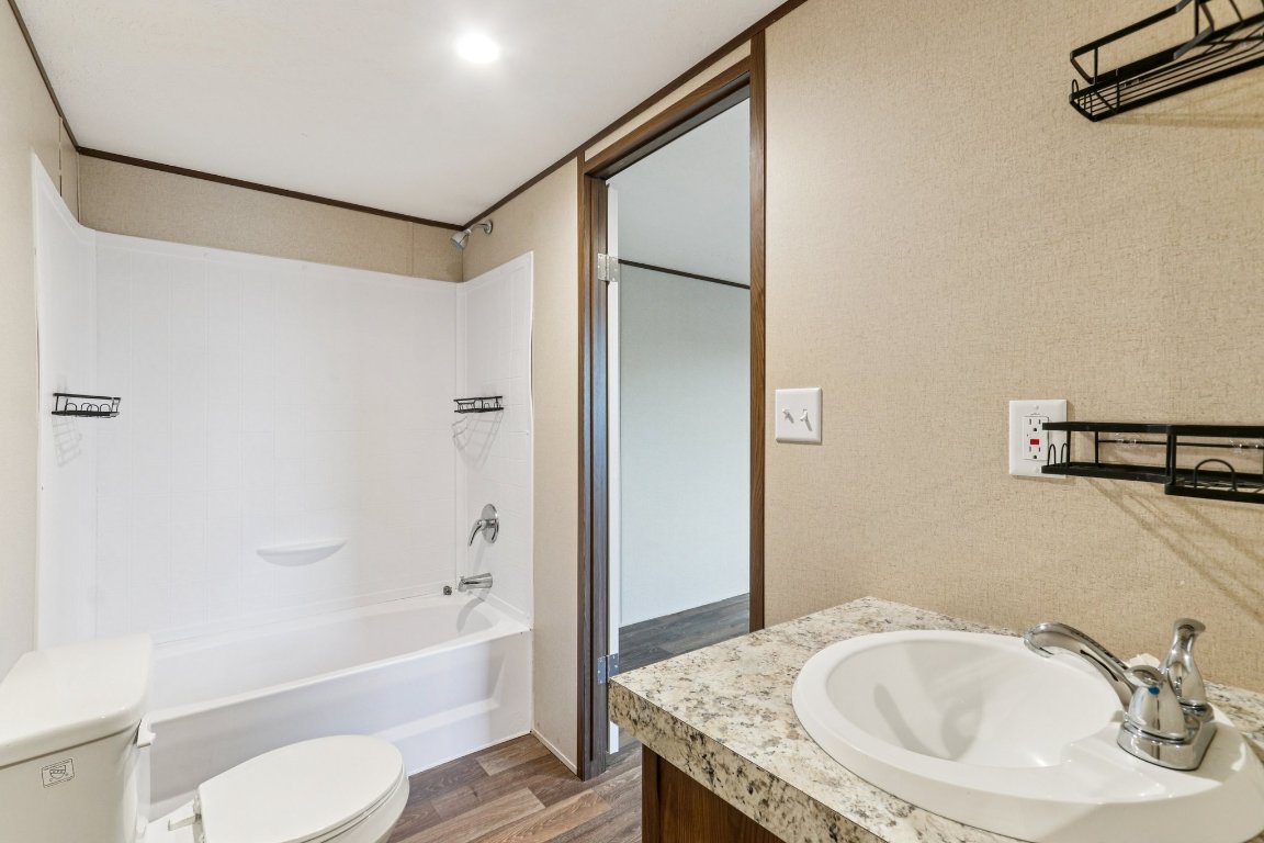 24369-2 Bingham Creek Road, Unit 8 Leander, TX 78641 - Photo 10 of 16 a bathroom with a granite countertop sink toilet and shower