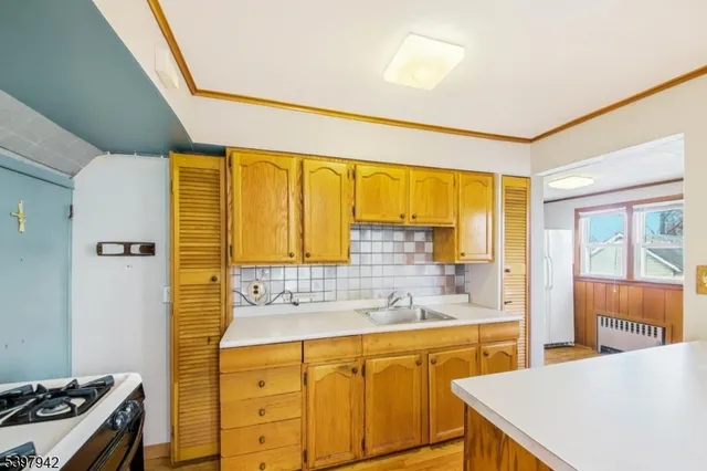 a view of an empty room with wooden floor and a ceiling fan