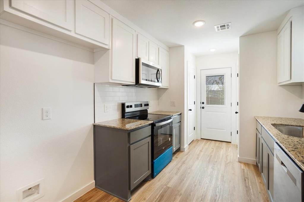 2408 Miller Street Denison, TX 75020 - Photo 11 of 26 a kitchen with stainless steel appliances granite countertop a sink stove and refrigerator