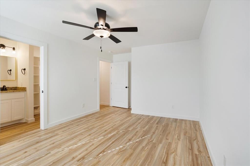 2408 Miller Street Denison, TX 75020 - Photo 14 of 26 a view of a room with wooden floor and a ceiling fan
