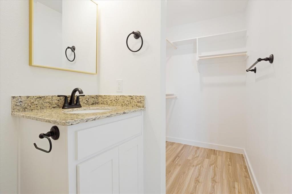 2408 Miller Street Denison, TX 75020 - Photo 17 of 26 a bathroom with a granite countertop sink a mirror and shower