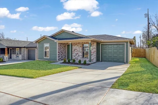 a front view of a house with a garden and trees