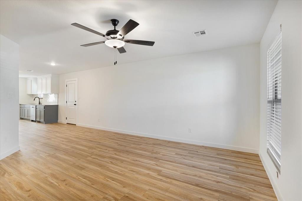 2408 Miller Street Denison, TX 75020 - Photo 4 of 26 a view of an empty room with wooden floor and a ceiling fan