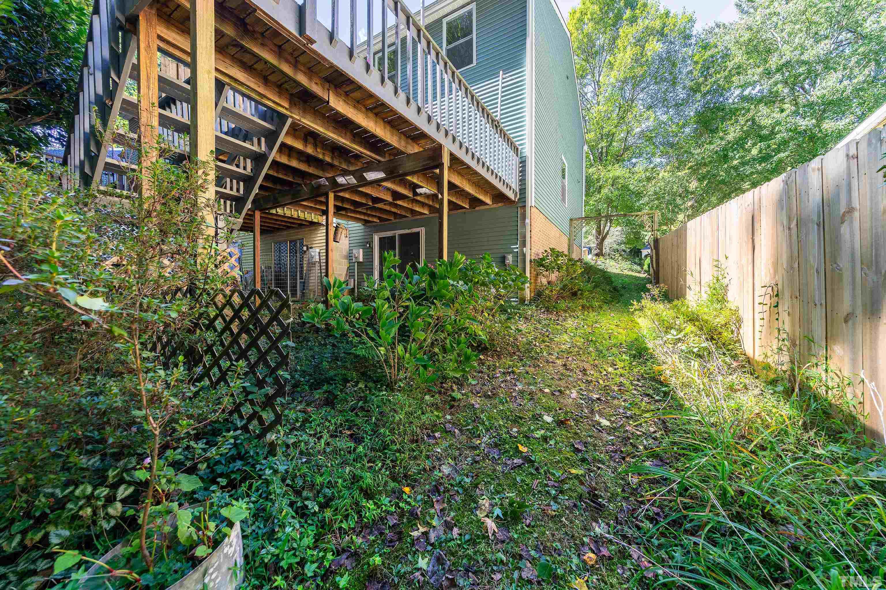 7328 Summerland Drive Raleigh, NC 27612 - Photo 22 of 22 a backyard of a building with large trees and plants