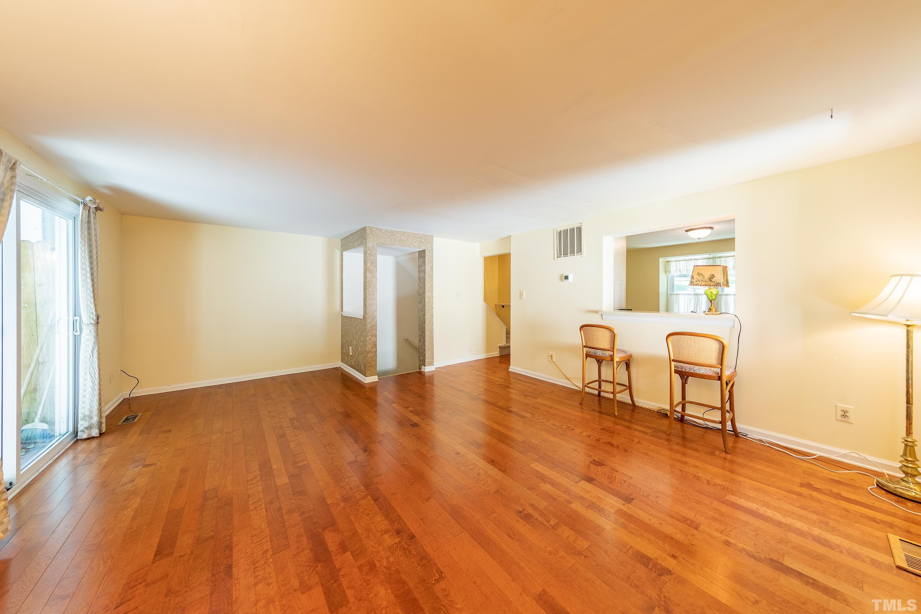 7328 Summerland Drive Raleigh, NC 27612 - Photo 10 of 22 a view of an empty room with window and wooden floor
