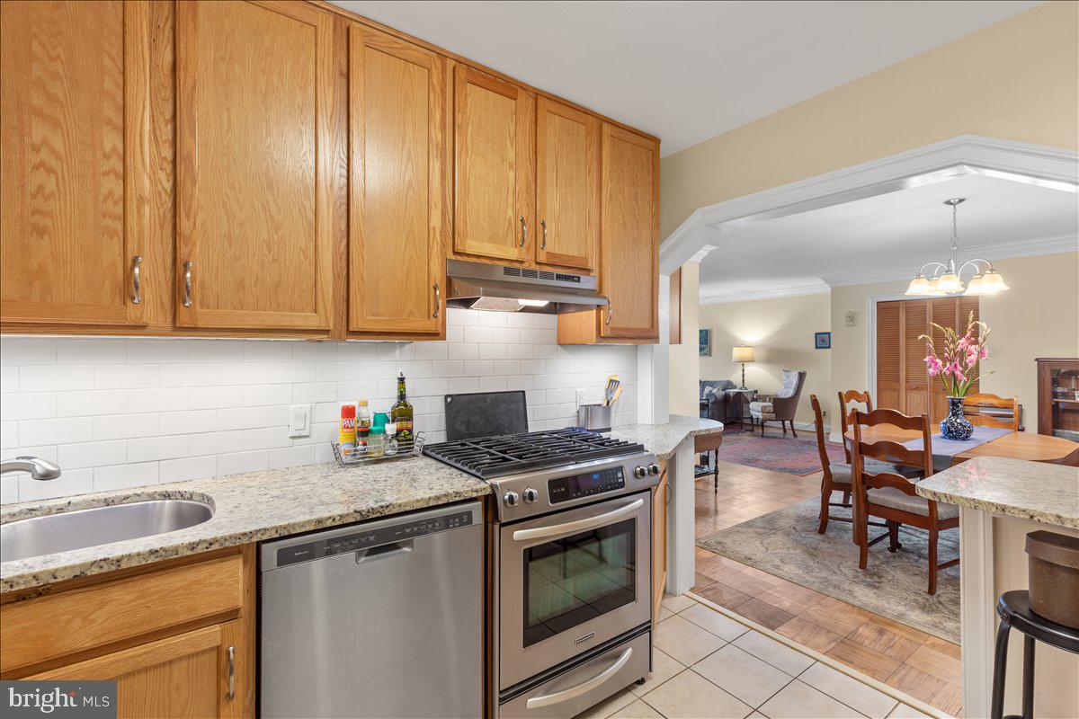 5101 River Road, Unit 1506 Bethesda, MD 20816 - Photo 11 of 37 a kitchen with granite countertop a stove sink and cabinets