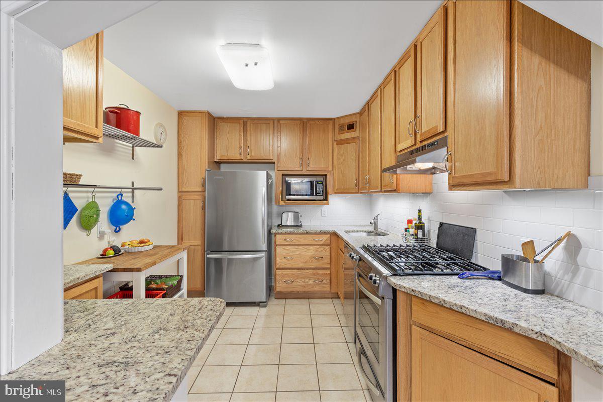 5101 River Road, Unit 1506 Bethesda, MD 20816 - Photo 8 of 37 a kitchen with stainless steel appliances granite countertop a refrigerator a stove and a sink