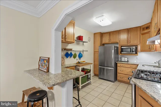 a kitchen with stainless steel appliances granite countertop a refrigerator stove and sink