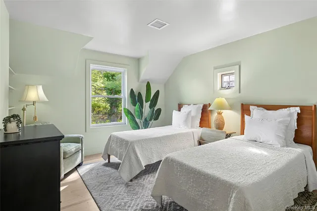 a bedroom with two beds and a lamp