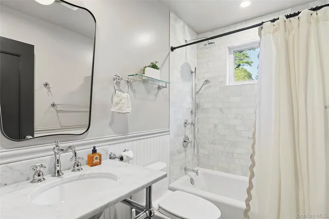 a bathroom with a granite countertop sink a toilet and a mirror