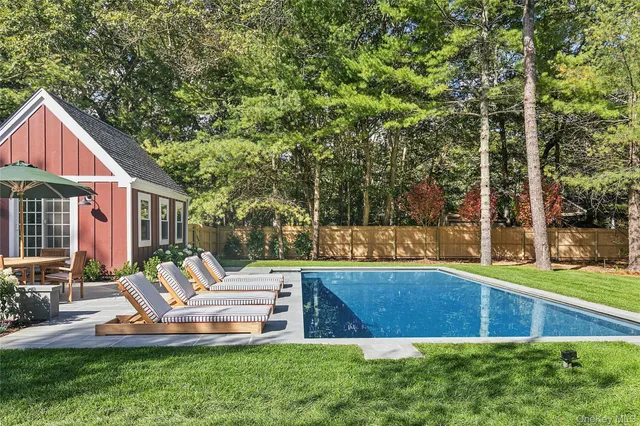 a view of backyard with swimming pool and patio