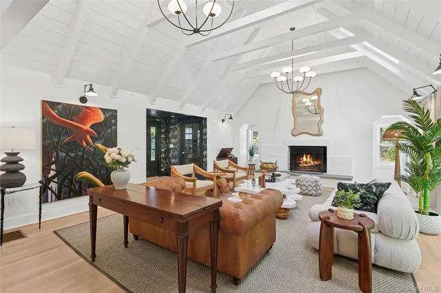 a living room with furniture a chandelier and a fireplace