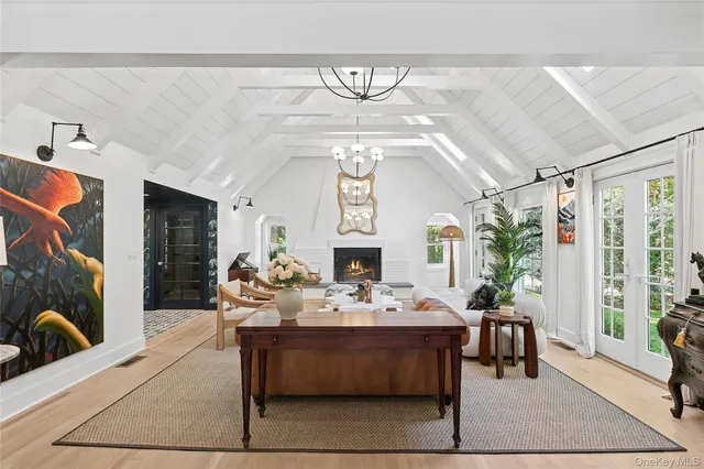 a living room with furniture a fireplace and a chandelier