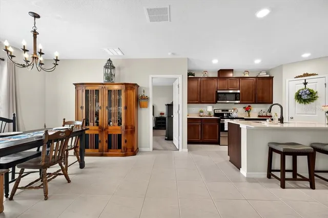 a kitchen with stainless steel appliances kitchen island granite countertop a refrigerator and a stove top oven