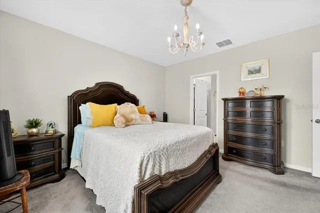 a bedroom with a bed and a chandelier
