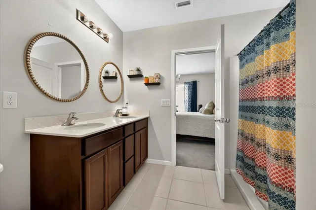 a en suite bathroom with a double vanity sink and a mirror