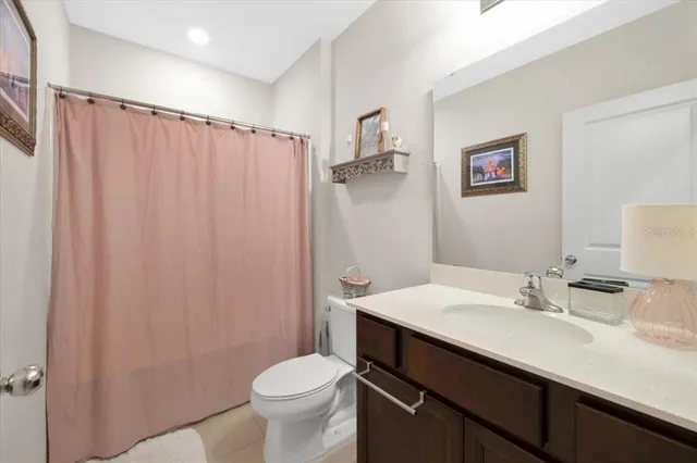 a bathroom with a sink a toilet a mirror and shower curtain
