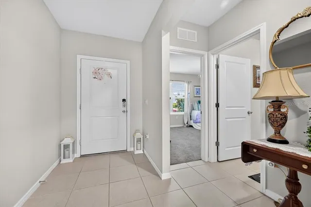 a view of a hallway with bathroom and mirror