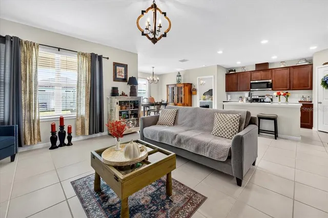 a living room with furniture kitchen view and a large window