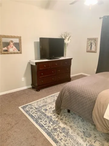 a living room with a dresser and a flat screen tv