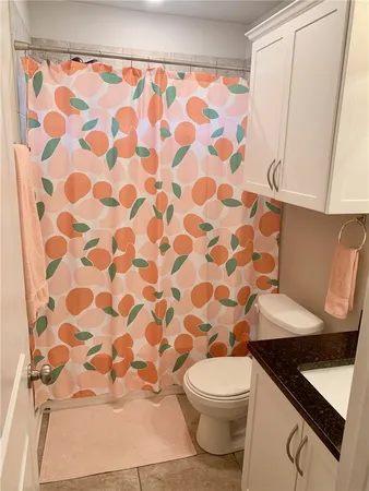 a bathroom with a granite countertop sink and a toilet