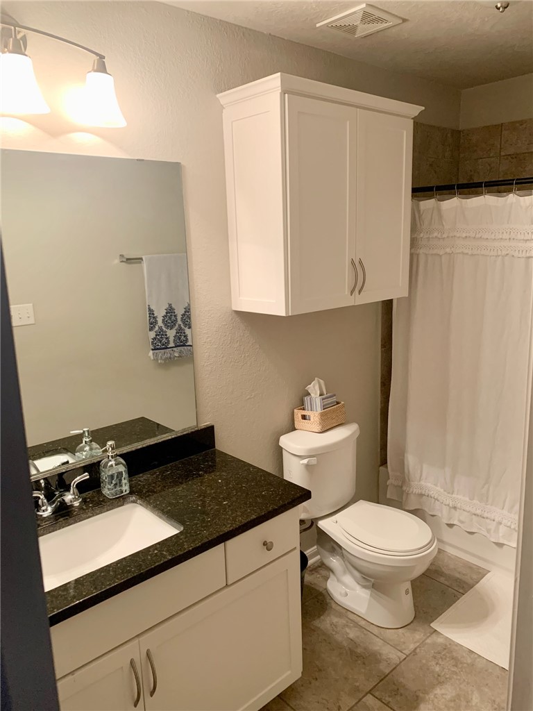 2019 Jester Trail Bryan, TX 77807 - Photo 20 of 25 a bathroom with a granite countertop sink and a toilet