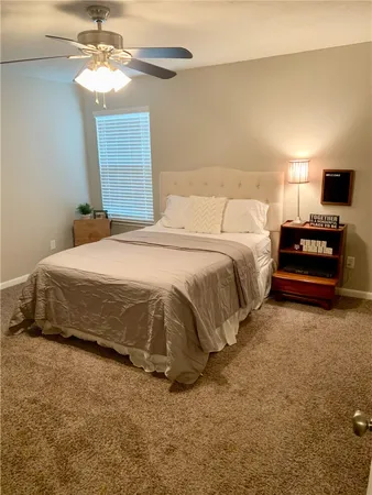 a bedroom with a bed and a ceiling fan