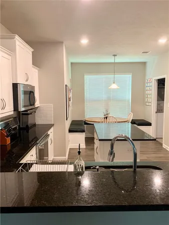 a living room with furniture a flat screen tv and kitchen view