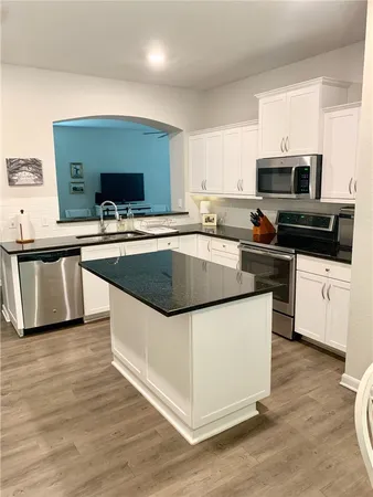 a kitchen with stainless steel appliances a sink a stove top oven a counter space and cabinets