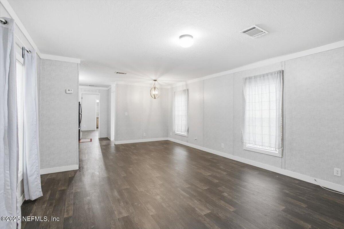 524 West Railroad Avenue Macclenny, FL 32063 - Photo 2 of 11 a view of an empty room with wooden floor and a window