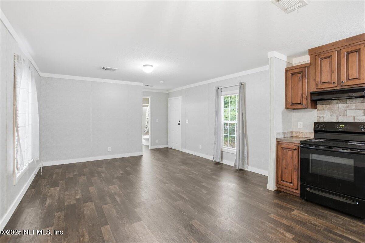 524 West Railroad Avenue Macclenny, FL 32063 - Photo 3 of 11 a view of a kitchen with wooden floor and a window