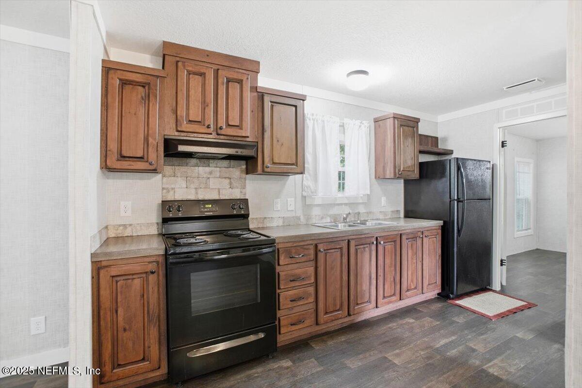524 West Railroad Avenue Macclenny, FL 32063 - Photo 4 of 11 a kitchen with stainless steel appliances granite countertop a stove refrigerator and cabinets