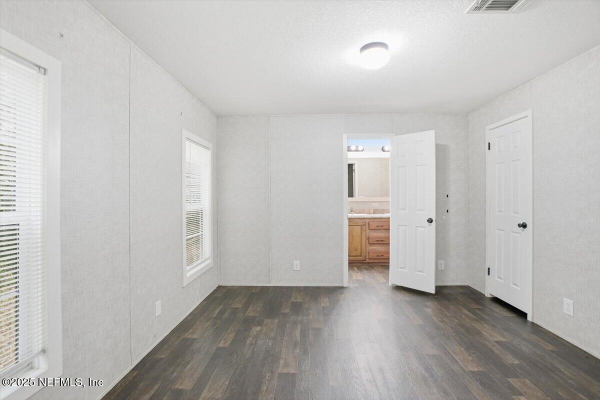 524 West Railroad Avenue Macclenny, FL 32063 - Photo 5 of 11 an empty room with wooden floor and windows