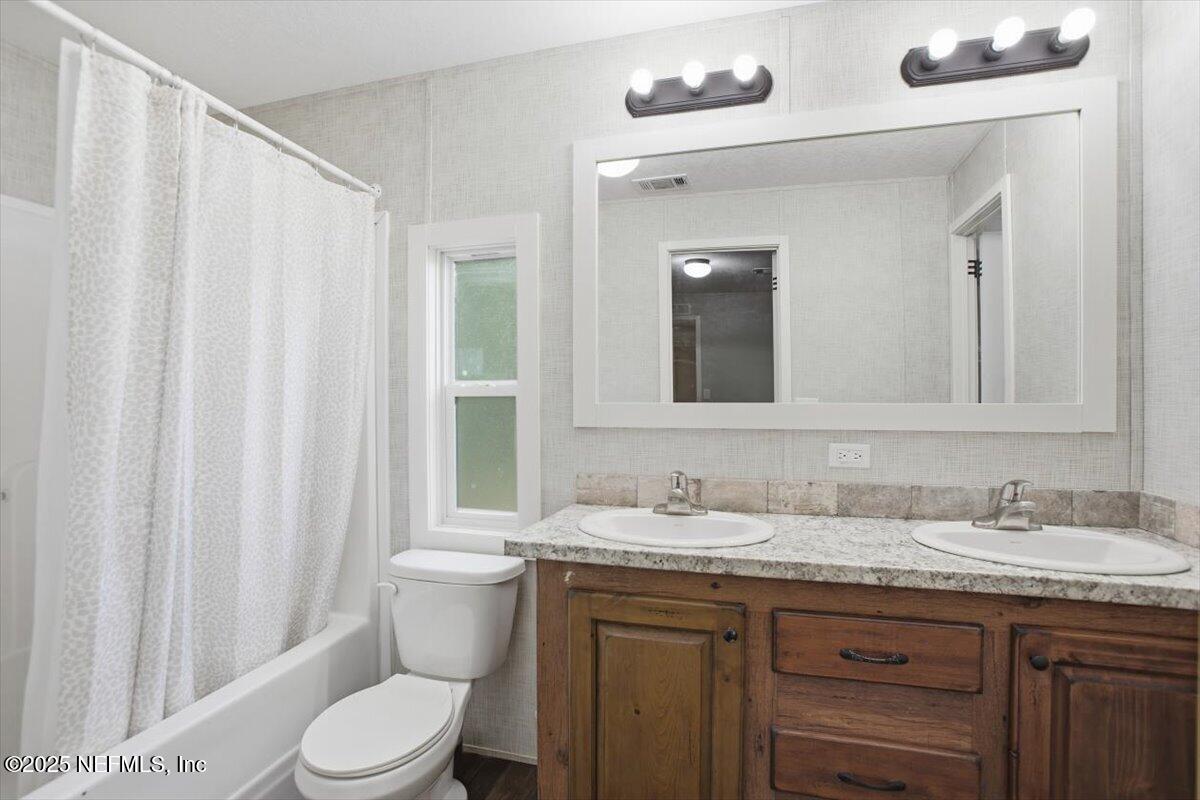 524 West Railroad Avenue Macclenny, FL 32063 - Photo 6 of 11 a bathroom with a granite countertop sink toilet and mirror