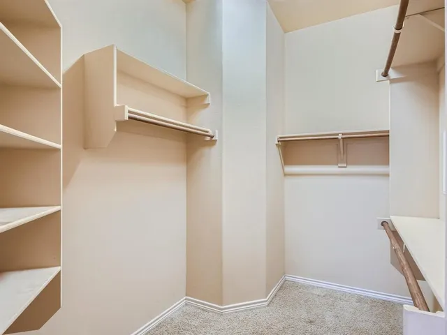 a view of walk in closet with empty racks