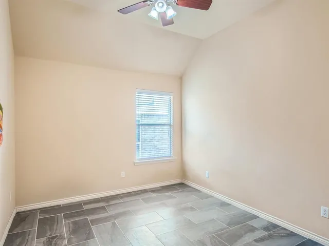 an empty room with a chandelier fan