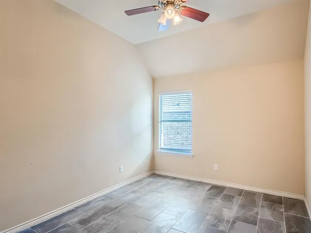 an empty room with a chandelier fan