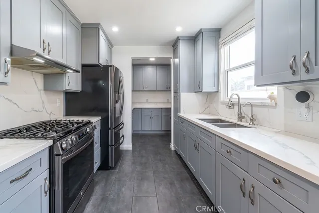 a kitchen with stainless steel appliances granite countertop a sink stove and refrigerator