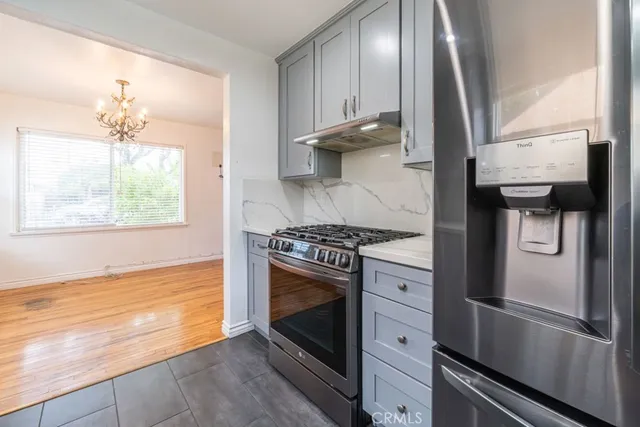 a kitchen with stainless steel appliances granite countertop a stove a refrigerator and a window