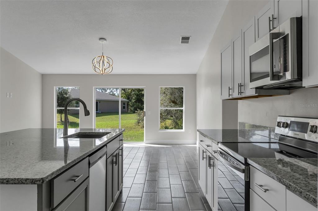 506 Peace Way Kissimmee, FL 34759 - Photo 13 of 34 a kitchen with stainless steel appliances granite countertop a sink and a stove