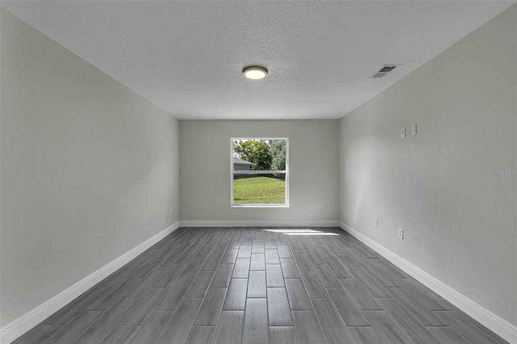 506 Peace Way Kissimmee, FL 34759 - Photo 19 of 34 wooden floor in an empty room with a window