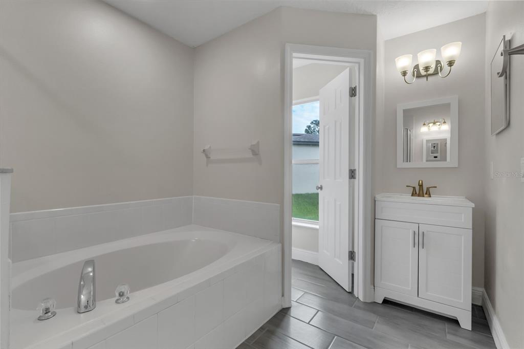 506 Peace Way Kissimmee, FL 34759 - Photo 23 of 34 a white bath tub sitting next to a bathroom sink